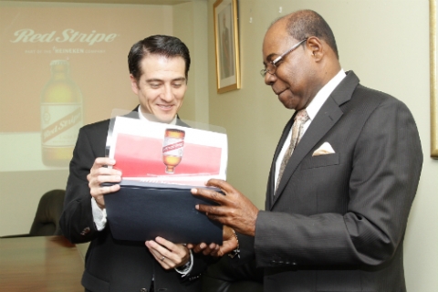 Minister of Tourism, Edmund Bartlett (right), shares Red Stripe's Managing Director Ricardo Nuncio's interest in a brochure on Red Stripe beer, during a courtesy call on the minister at his office in New Kingston on Wednesday. 
