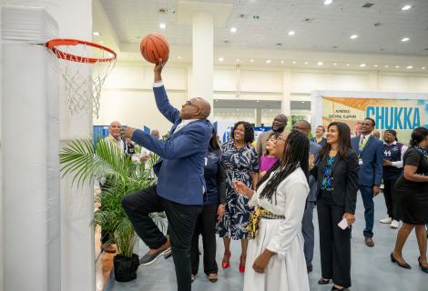 Minister Bartlett shoots at basketball at the hoop during his JAPEX 2025 trade floor walkthrough. 