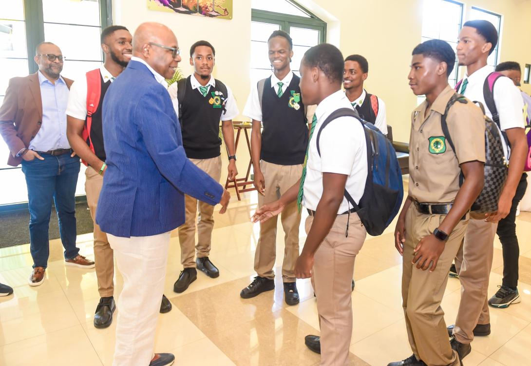 Minister of Tourism, Hon. Edmund Bartlett (3rd left) engages in a brief discussion with Tourism Action Club members from Calabar High School on his arrival at the Montego Bay Convention Centre on Friday, September 26, 2025 for the World Tourism Day 2025 Youth Forum. Sharing in the moment (left) is Director of Tourism, Donovan White. 