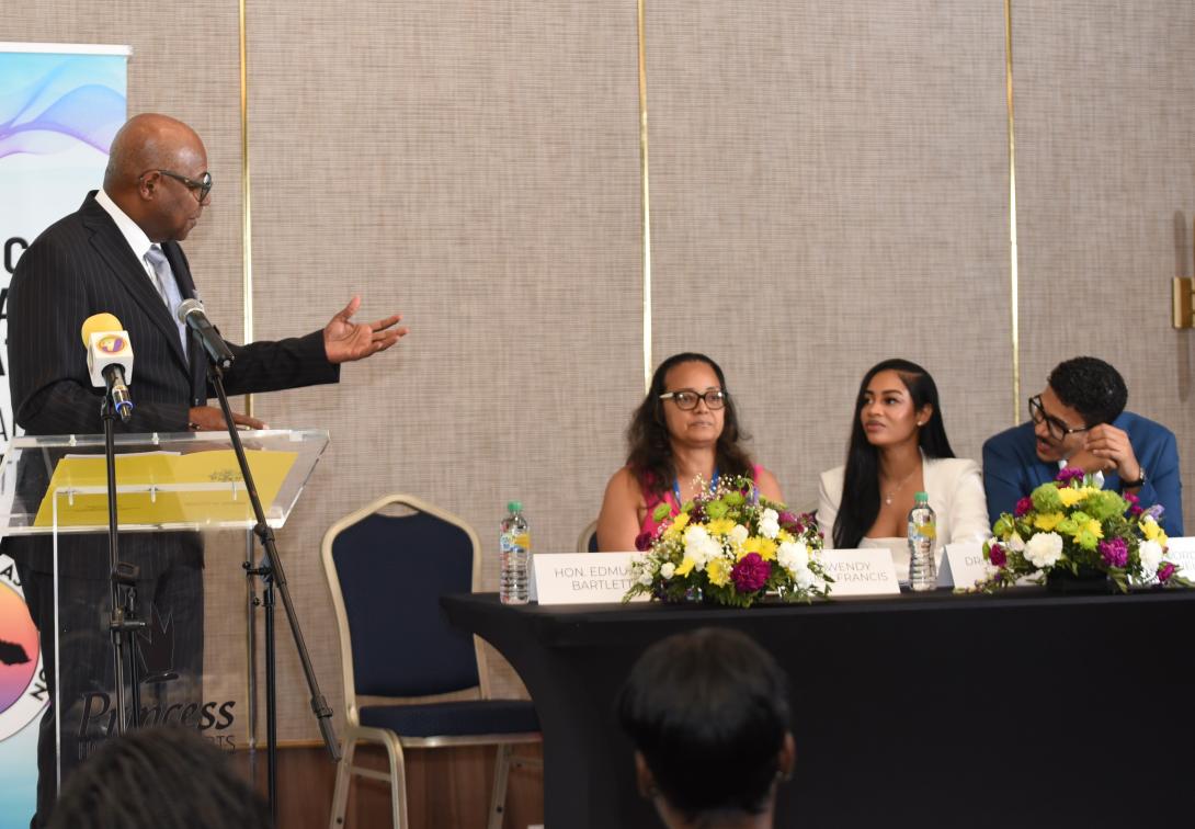 Minister of Tourism, Hon. Edmund Bartlett (left) throws out a challenge to the Jamaica Dental Association (JDA) to partner in Jamaica’s drive to secure a share of the lucrative dental health tourism market. He delivered the keynote address at the 62nd convention of the JDA at the Princess Grand Jamaica in Green Island, Hanover, on Thursday, May 21, 2026, directing his remarks to (seated from left) JDA President, Dr. Wendy Chuck-Francis; Convention Chair, Dr. Chinel  Lee and co-chair, Dr. Jordan McNeil.