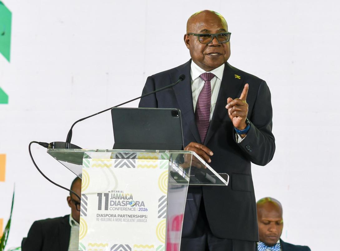 Minister of Tourism, Hon Edmund Bartlett addresses members of the Jamaican Diaspora and urges them to invest in Jamaica’s tourism industry and be its ambassadors. He was leading a panel discussion at the 11th Biennial Jamaica Diaspora Conference at the Montego Bay Convention Centre on Tuesday, June 16, 2026. Partly hidden (seated at left), is Director of Tourism, Donovan White and at right, Permanent Secretary in the Ministry of Water, Environment and Climate Change, Mr. Wayne Robertson.